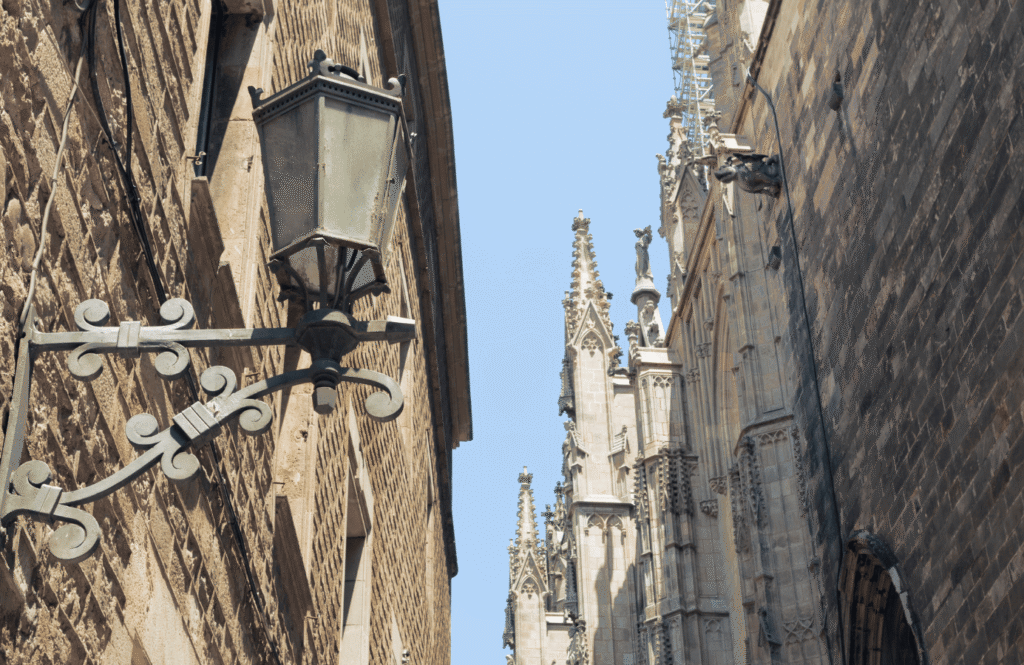 Wąska uliczka z gotyckimi detalami i latarniami w Barri Gòtic, historycznej dzielnicy Barcelony