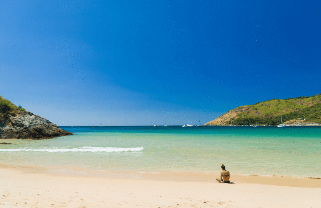 Spokojna, piaszczysta plaża Nai Harn z łagodnym zejściem do wody i błękitnym niebem, Phuket, Tajlandia