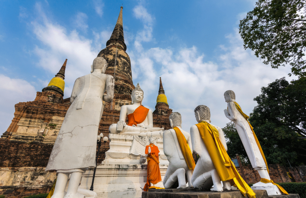 Wat Yai Chai Mongkhon – stupy i rząd siedzących posągów Buddy w pomarańczowych szatach, Ayutthaya, Tajlandia