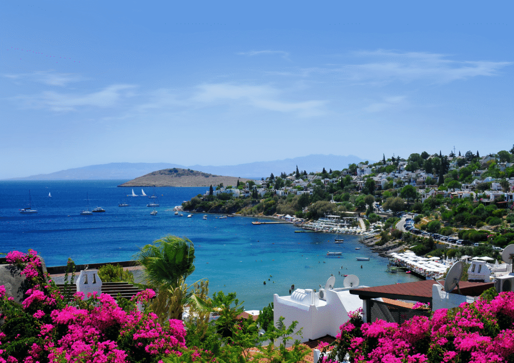 Panorama Bodrum z białymi budynkami, bujną roślinnością i błękitnym morzem w tle, Turcja Egejska