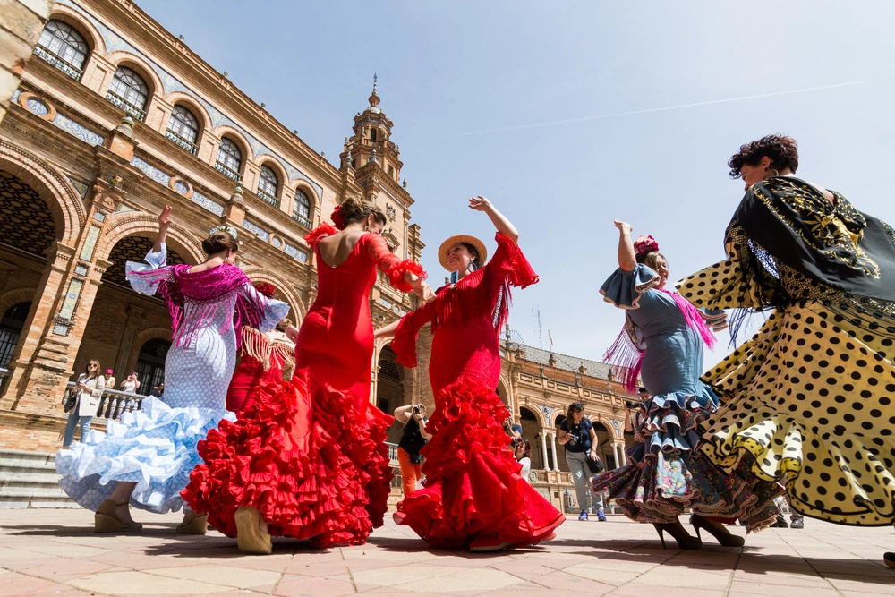 Tancerki flamenco w kolorowych strojach tańczące na placu w Sewilli – hiszpańska fiesta i tradycja