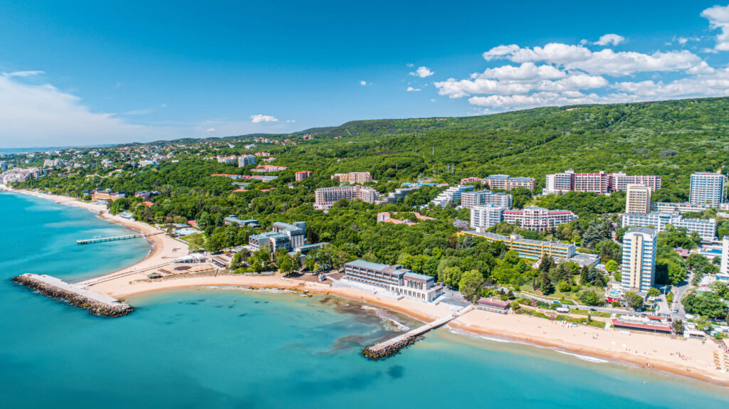 Widok z lotu ptaka na nadmorski kurort w Bułgarii: piaszczysta plaża, palmy i turkusowe Morze Czarne
