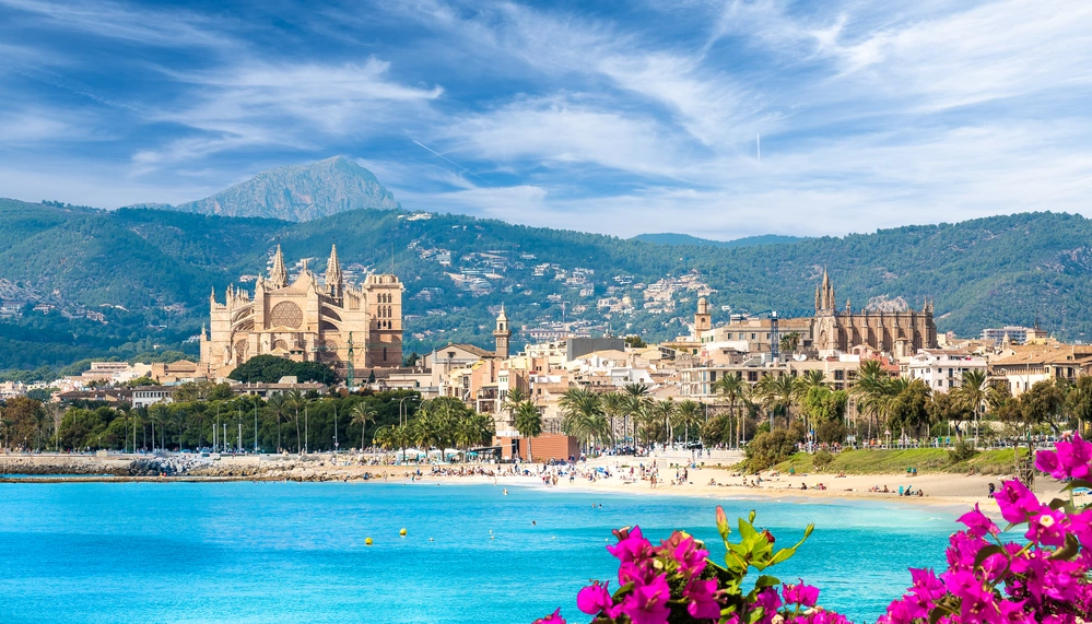 Majorka – widok na plażę i katedrę La Seu w Palmie, w tle góry Serra de Tramuntana