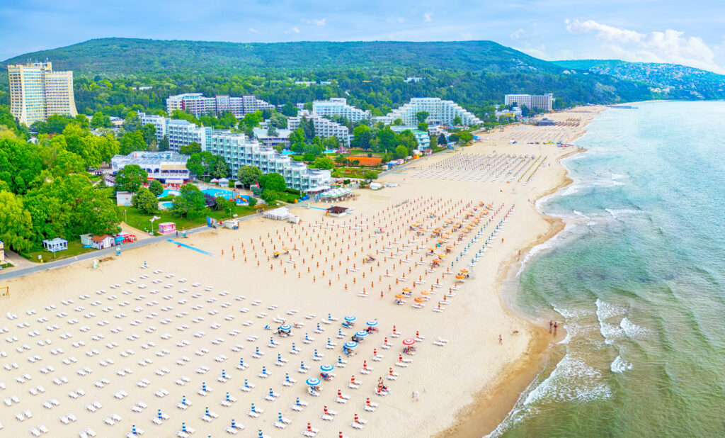 Panorama kurortu Albena w Bułgarii All Inclusive – szeroka plaża, rzędy leżaków i turkusowe wody Morza Czarnego.