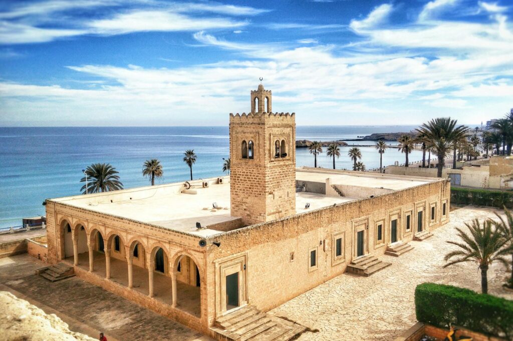 Plac w centrum Monastiru z palmami i meczetem Habiba Bourguiby w tle.