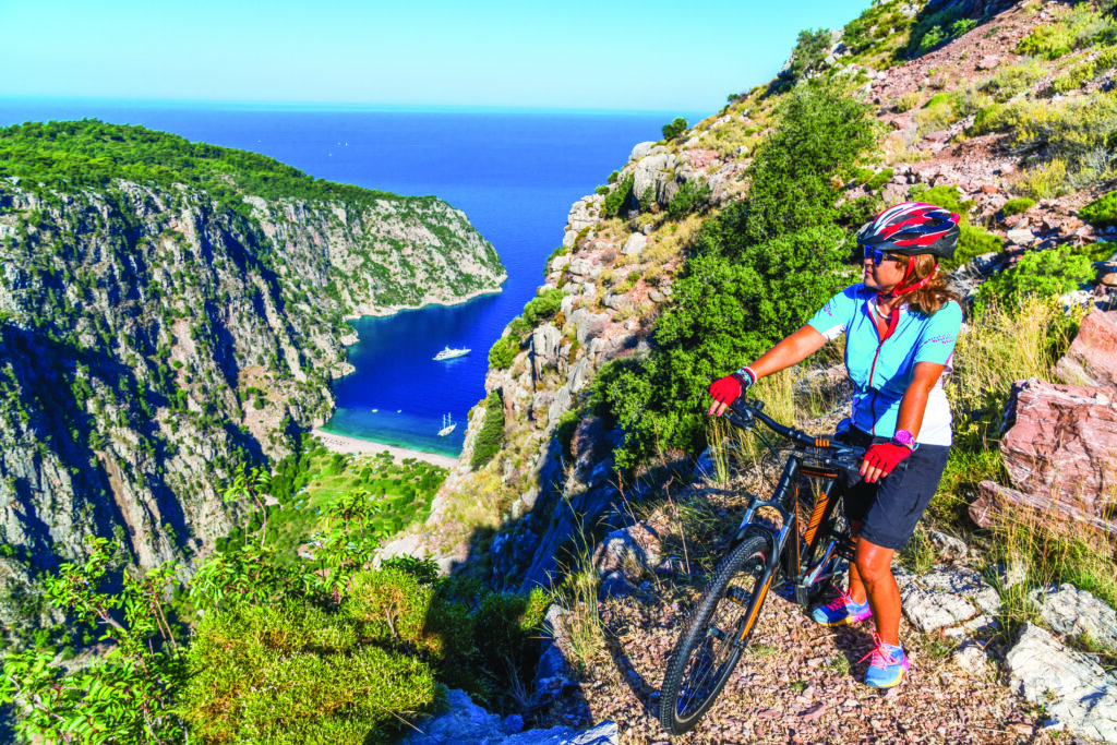 Rowerzystka podziwia Dolinę Motyli w Oludeniz – aktywny wypoczynek w Turcji All Inclusive.