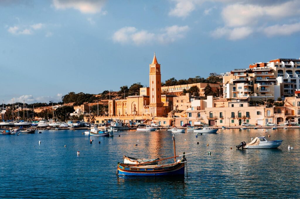 Kościół i kolorowe łodzie w porcie Marsaskala na Malcie