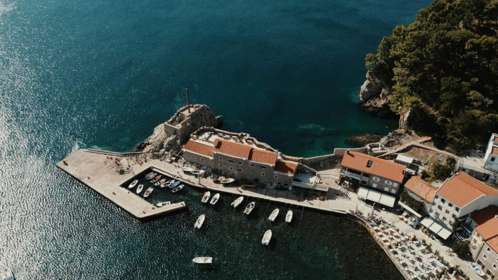 Flaga Czarnogóry powiewająca nad Adriatykiem i miastem Kotor