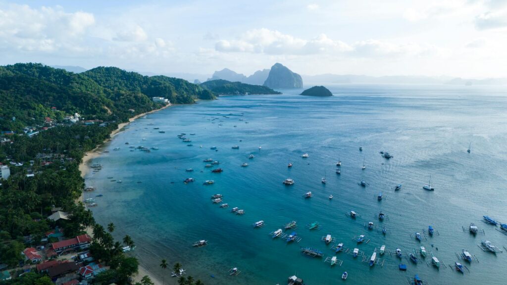 Kobieta siedząca na łodzi w El Nido, Palawan – turkusowa laguna i wapienne skały