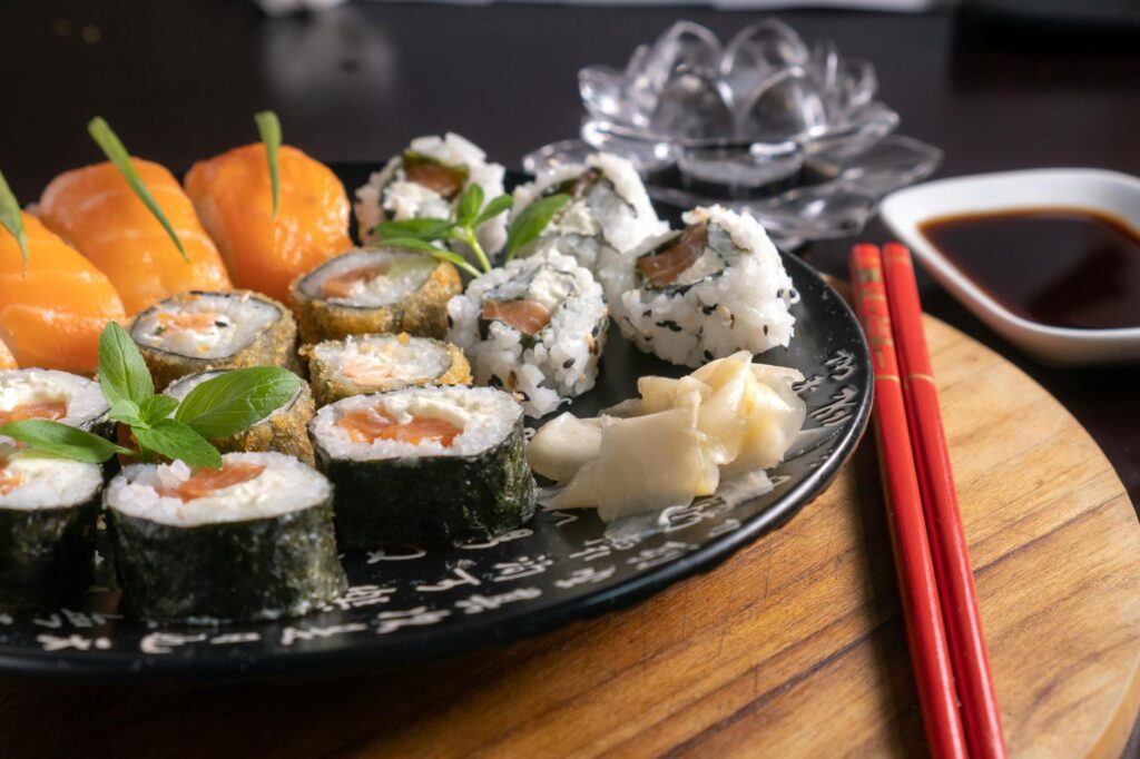 Tradycyjne sushi podane na japońskich talerzach, różnorodne nigiri, sashimi i rolki