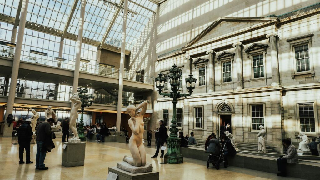 Wnętrze Metropolitan Museum of Art w Nowym Jorku z rzeźbami i turystami