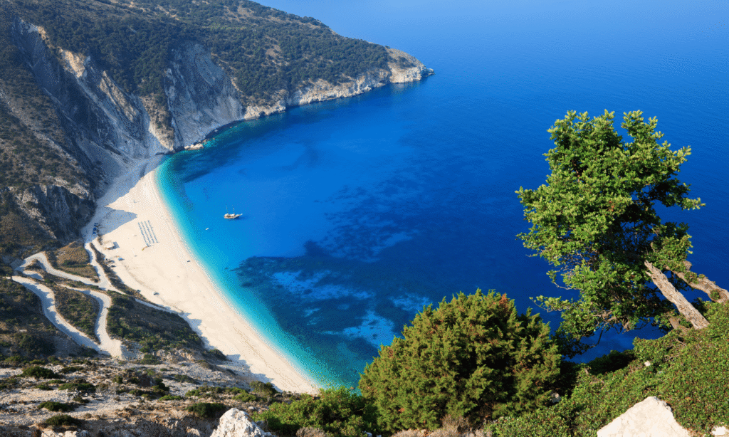 Plaża Myrtos na Kefalonii z białym piaskiem i turkusowym morzem otoczona stromymi klifami.