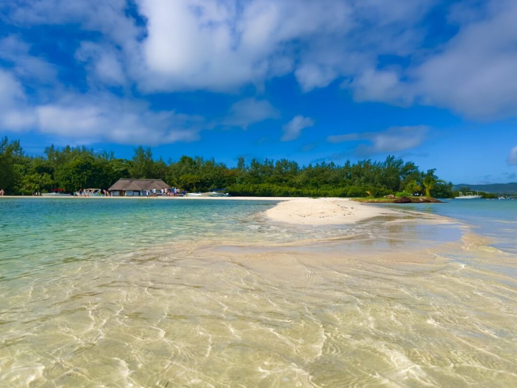 Kamienie na piasku układające się w napis Mauritius na rajskiej plaży