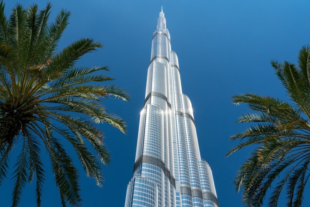 Burj Khalifa w Dubaju na tle błękitnego nieba i otaczających go nowoczesnych budynków