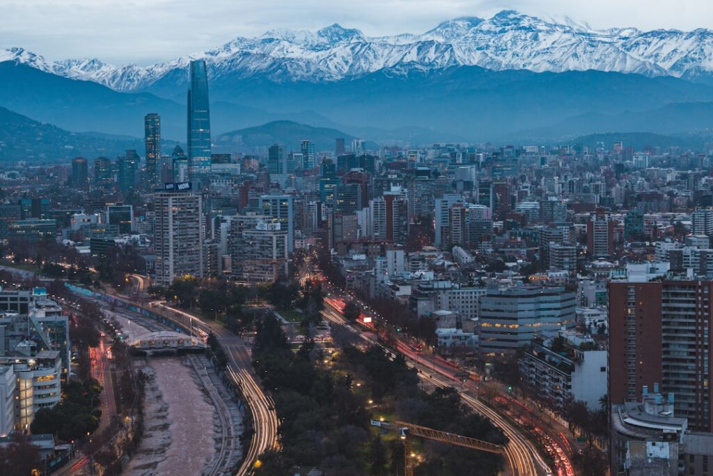 Katedra w Santiago de Chile na tle nowoczesnych wieżowców i palm o zachodzie słońca