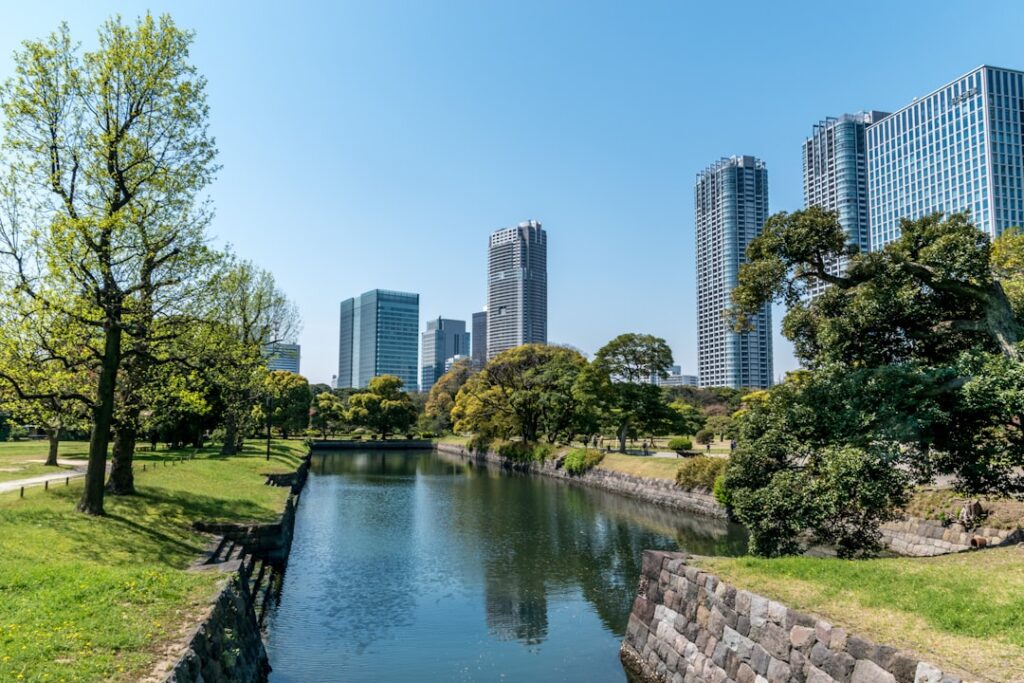 Tradycyjny japoński ogród Hamarikyu w Tokio z jeziorem, drzewami i panoramą wieżowców w tle