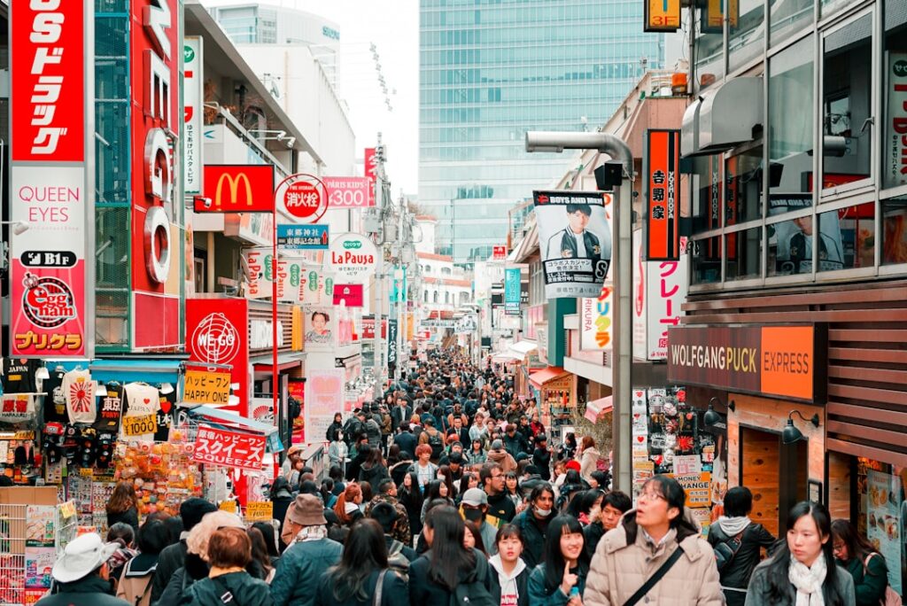Tłum spacerujących po ulicy Takeshita w dzielnicy Harajuku w Tokio, pełnej sklepów, neonów i modnych lokali