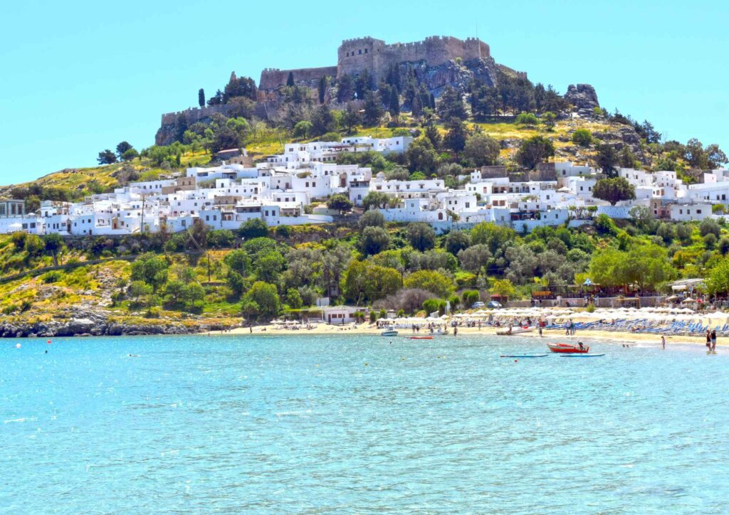 Panorama Lindos z białą zabudową i Akropolem na wzgórzu nad zatoką, Rodos