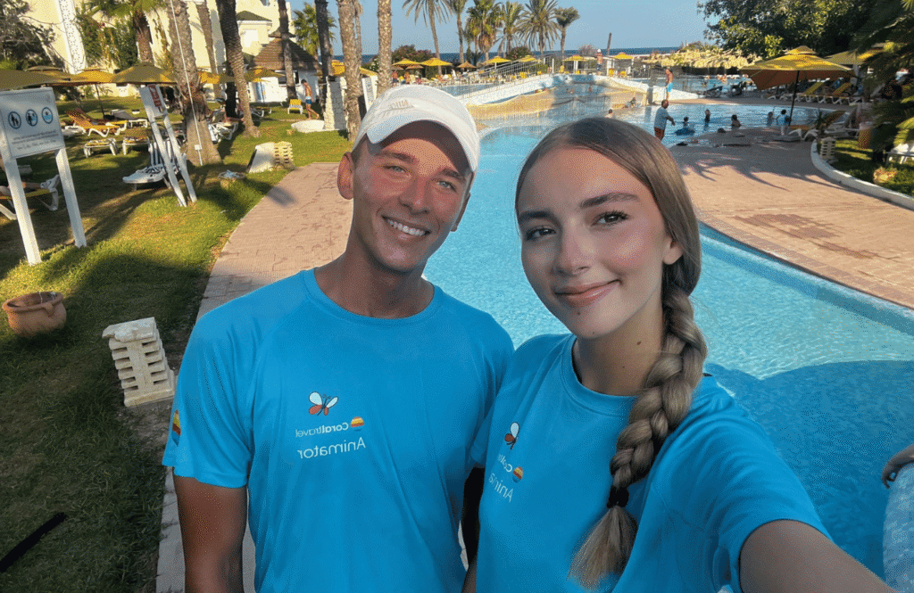 Polscy animatorzy Coral Family Club uśmiechają się do selfie przy basenie hotelowym.