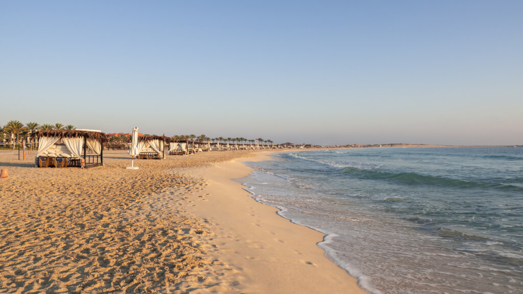 Plaża w Marsa Matrouh w Egipcie o zachodzie słońca – altany z palmowym dachem i spokojne Morze Śródziemne