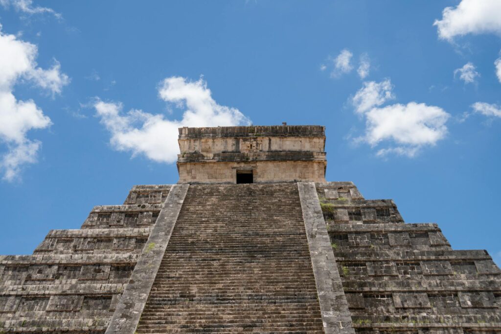 Turystka w kapeluszu podziwia Piramidę Kukulkana w Chichén Itzá, Meksyk