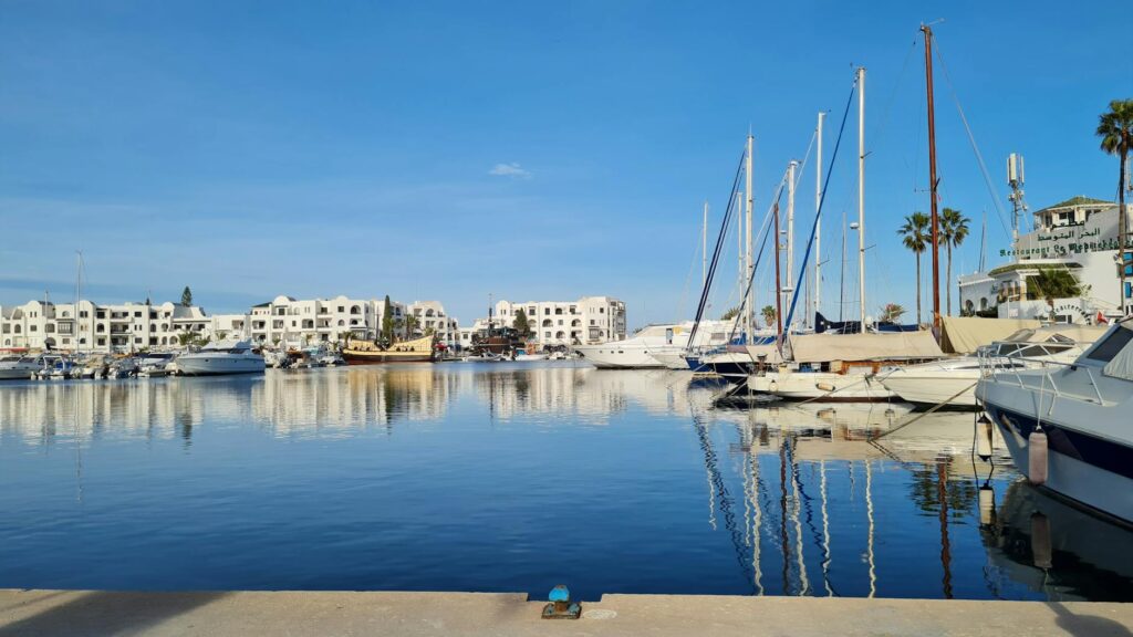Widok na port jachtowy w Tunezji z lazurowym morzem i górami w tle