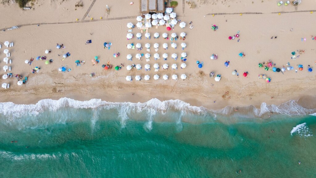 Widok z lotu ptaka na piaszczystą plażę nad Morzem Czarnym w Bułgarii z parasolami i turkusową wodą