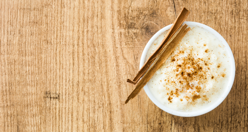 Dominikański deser arroz con leche – ryż na mleku z cynamonem w miseczce na drewnianym stole
