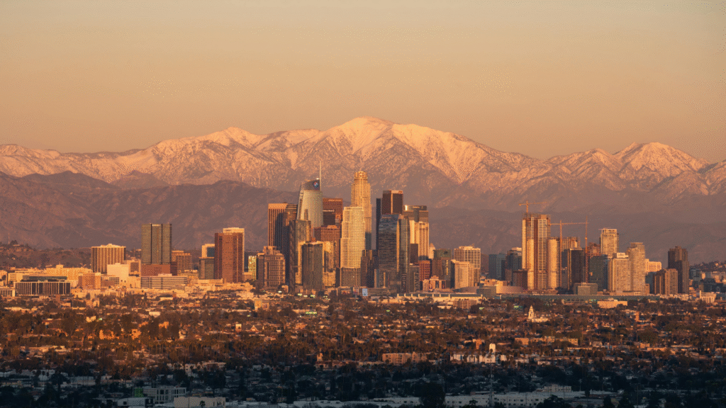 Panorama Los Angeles o zachodzie słońca z ośnieżonymi górami San Gabriel w tle