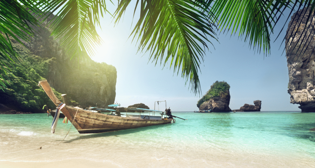 Phi Phi Island w Tajlandii – tropikalna plaża z tradycyjną łodzią i turkusowym morzem.