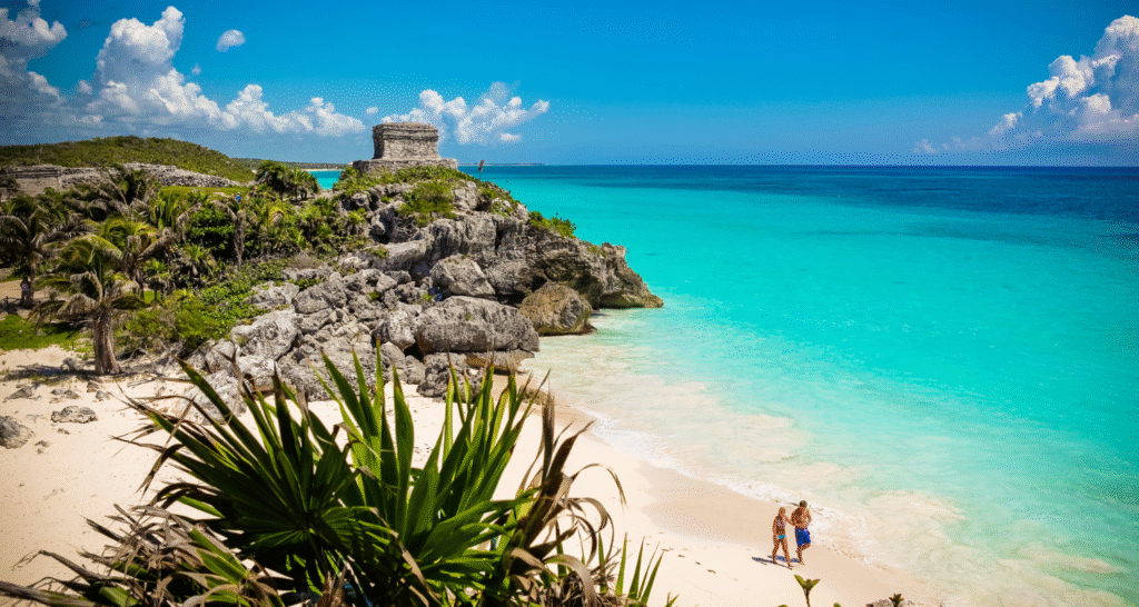 Plaża Tulum w Meksyku z turkusową wodą, białym piaskiem i ruinami Majów na skalistym klifie