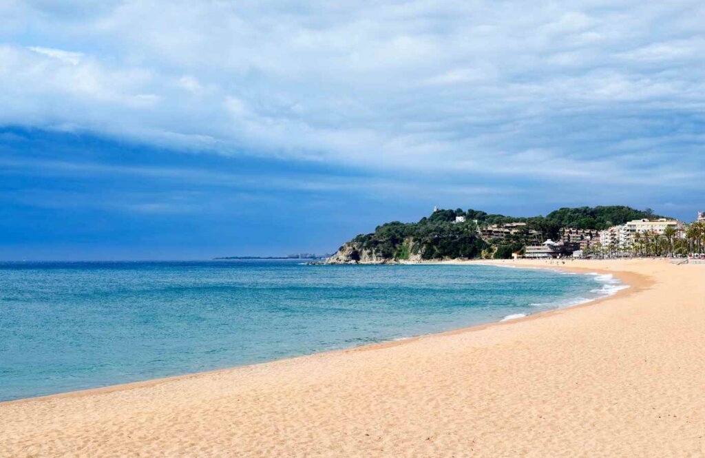 Szeroka, piaszczysta plaża w Lloret de Mar na Costa Barcelona z łagodnym zejściem do morza, Hiszpania