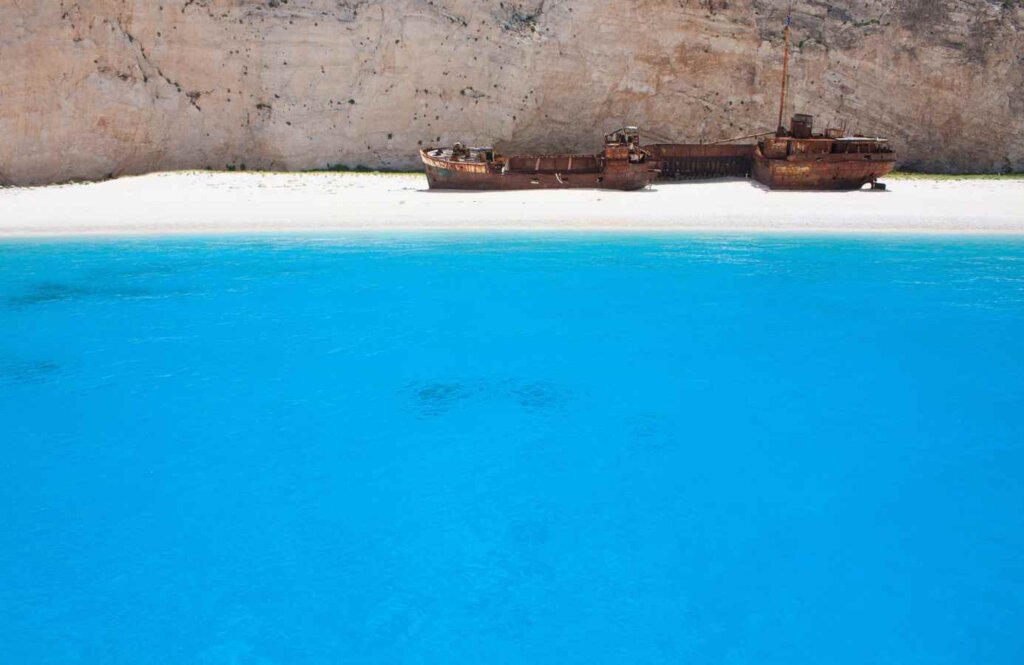 Zatoka Navagio z wrakiem statku na plaży otoczonej wysokimi klifami – kultowe miejsce na Zakynthos, Grecja