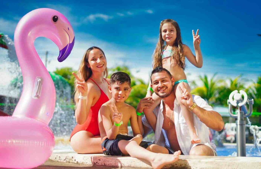 Rodzina z dziećmi i dmuchanym flamingiem na plaży – beztroskie wakacje z Coral Travel