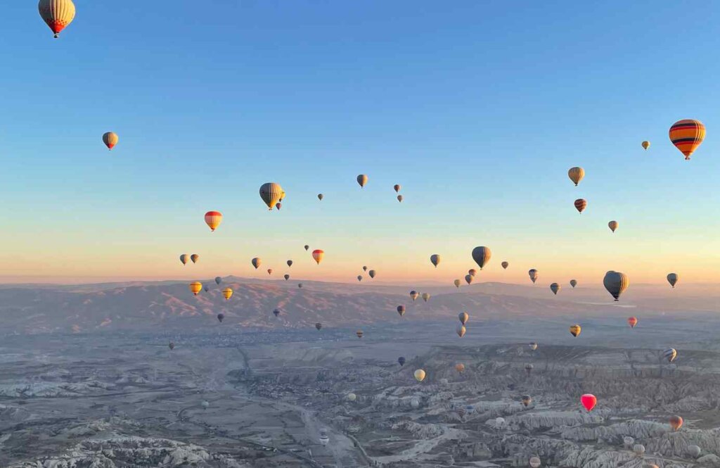 Balony unoszące się o poranku nad zaśnieżoną Kapadocją – zimowe loty balonem w Turcji