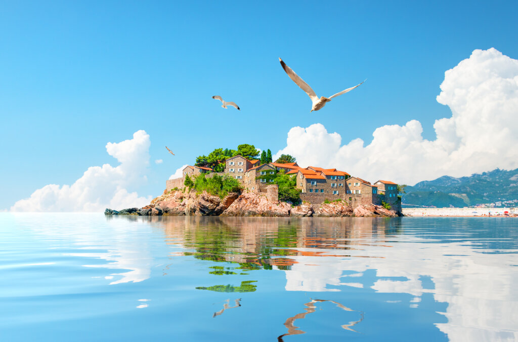 Wyspa Sveti Stefan w pobliżu Budvy w Czarnogórze, otoczona turkusowym morzem i górami w tle