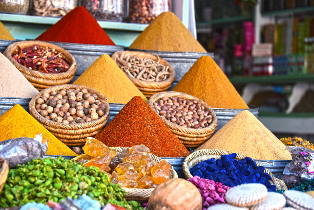 Kolorowe przyprawy na arabskim bazarze w Tunezji ułożone w piramidy z kurkumy, chili i cynamonu