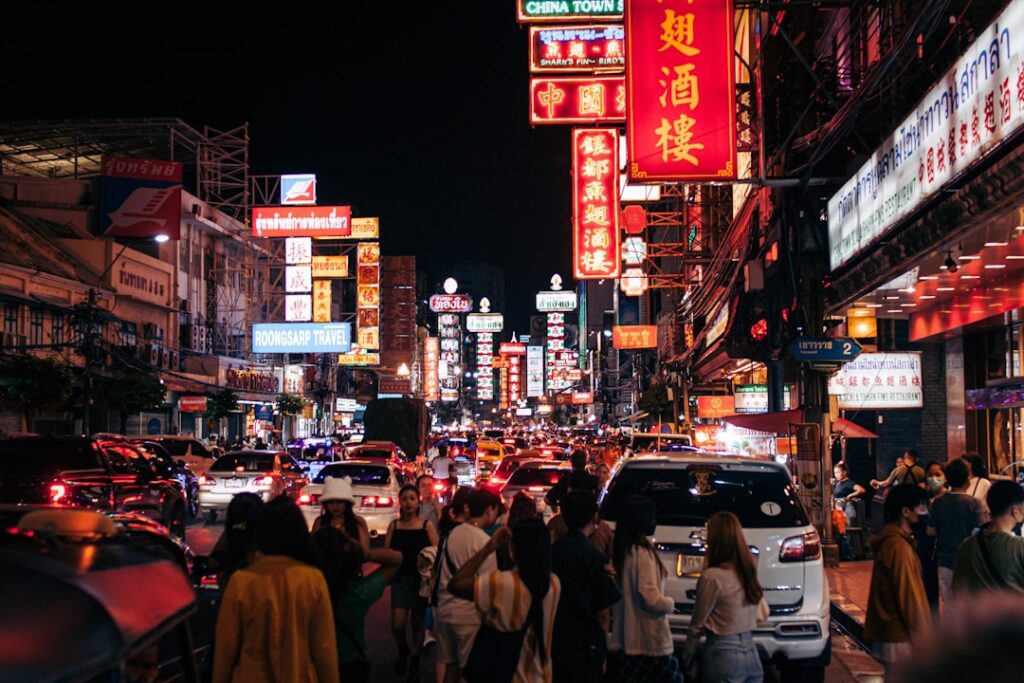Nocne ulice Chinatown w Bangkoku pełne neonów i ruchu miejskiego