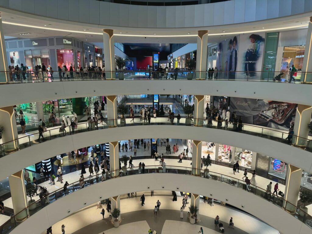 Wnętrze Dubai Mall z tłumem turystów i eleganckimi butikami w Zjednoczonych Emiratach Arabskich