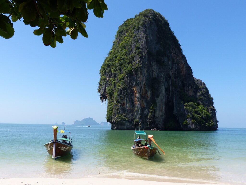Wysokie klify porośnięte zielenią i plaża w regionie Krabi w Tajlandii