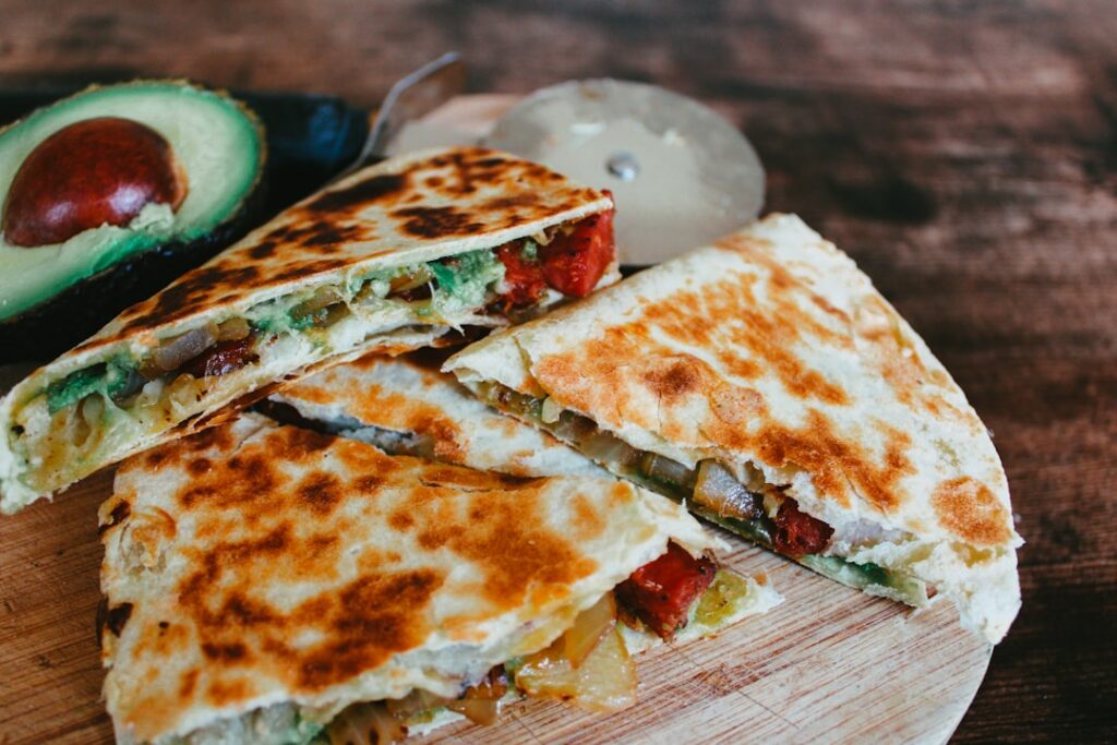 Quesadilla z roztopionym serem i mięsnym farszem, pokrojona na kawałki i podana z salsą