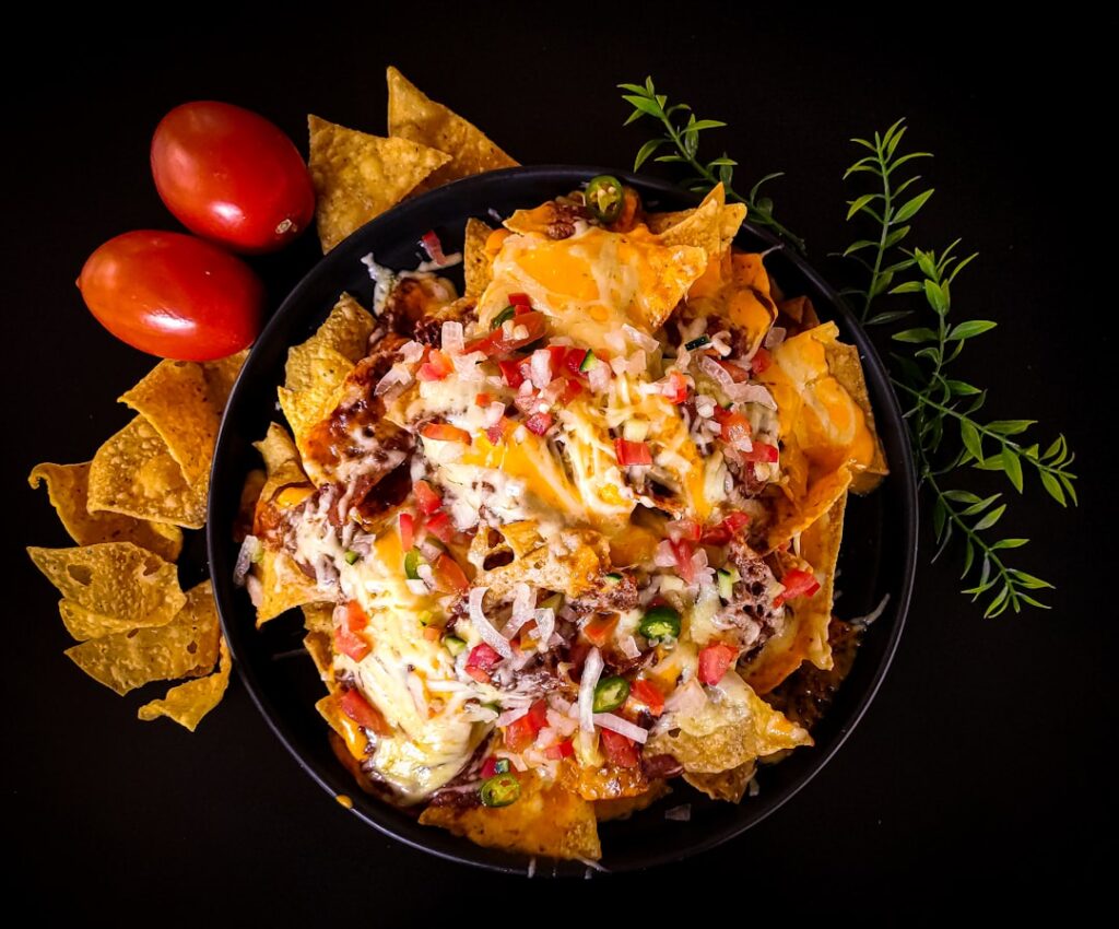 Miska nachos z serem, śmietaną, salsą i świeżą kolendrą