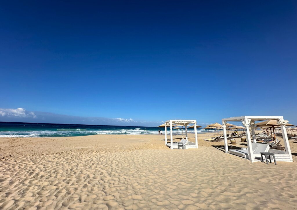 Szeroka, piaszczysta plaża przy hotelu Cleopatra Sidi Henish nad Morzem Śródziemnym