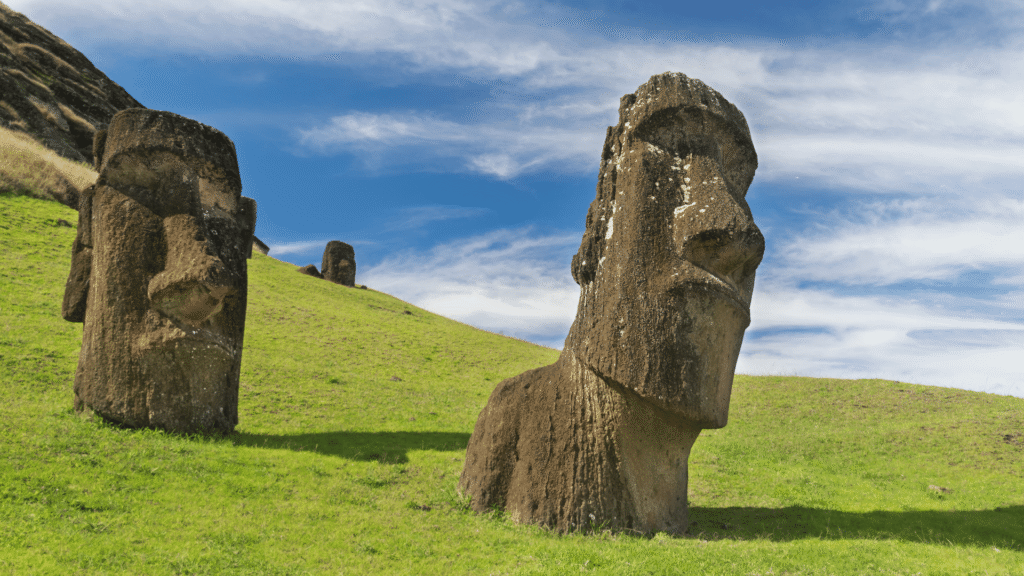 Pojedynczy posąg Moai na tle zielonych wzgórz Wyspy Wielkanocnej