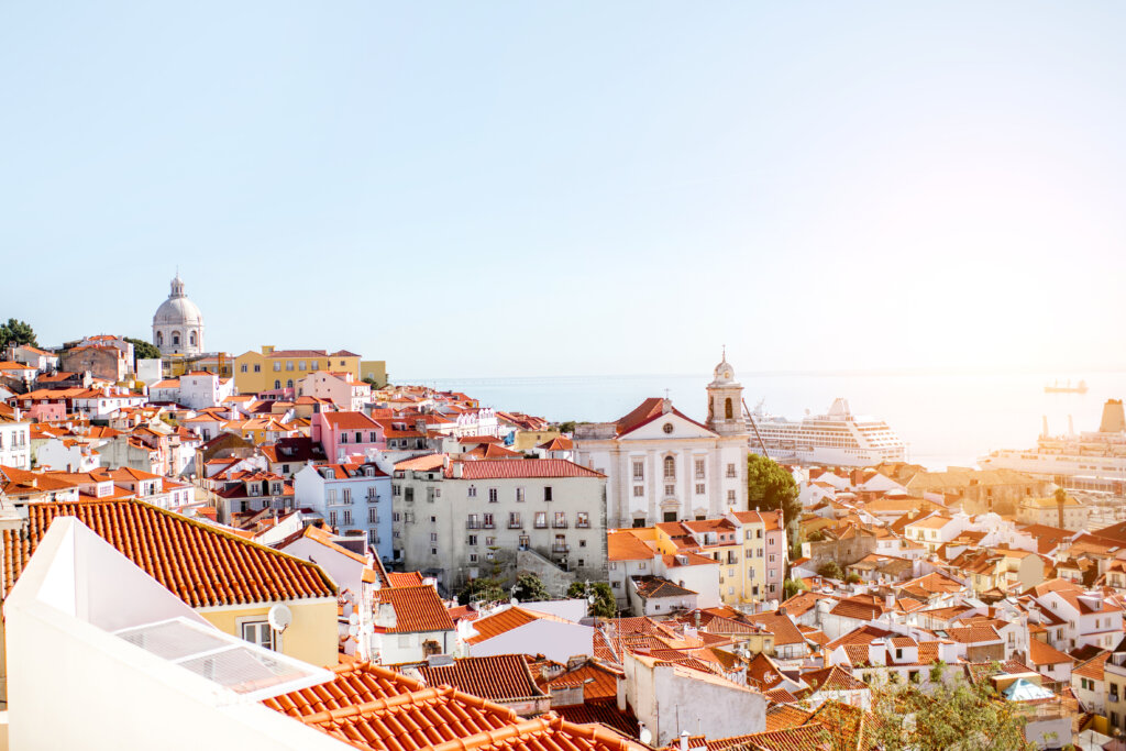 Panorama dzielnicy Alfama z czerwonymi dachami i widokiem na rzekę Tag