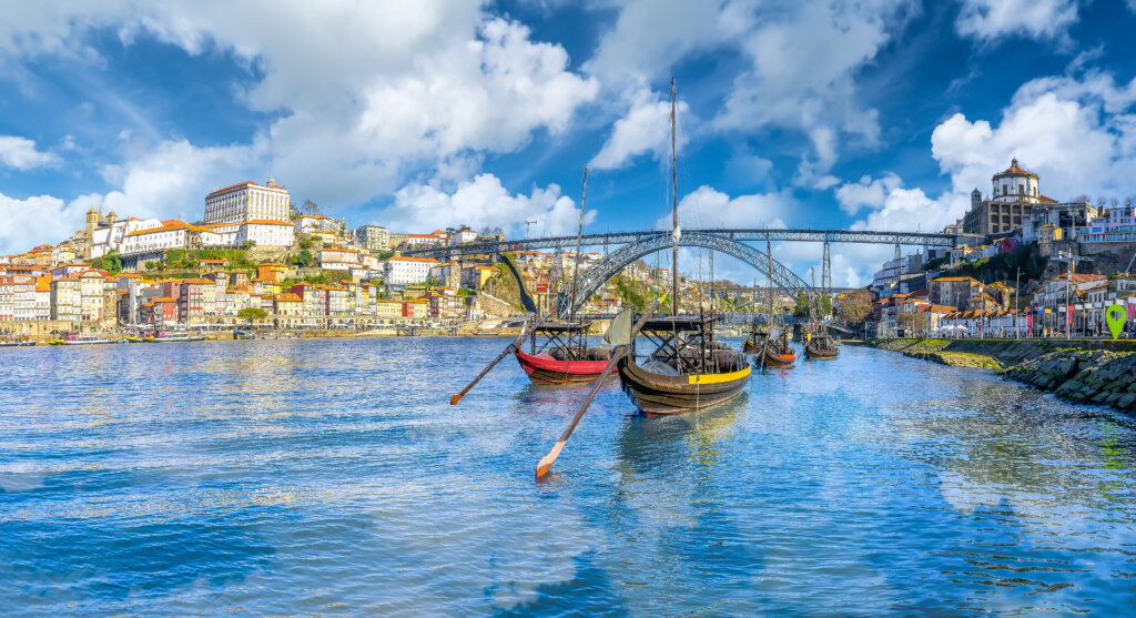 Porto nad rzeką Douro z tradycyjnymi łodziami i mostem Dom Luís I