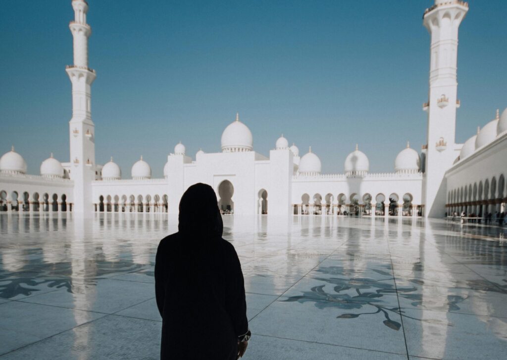 Osoba w tradycyjnym stroju stoi na dziedzińcu Wielkiego Meczetu Szejka Zayeda w Abu Dhabi w czasie ramadanu
