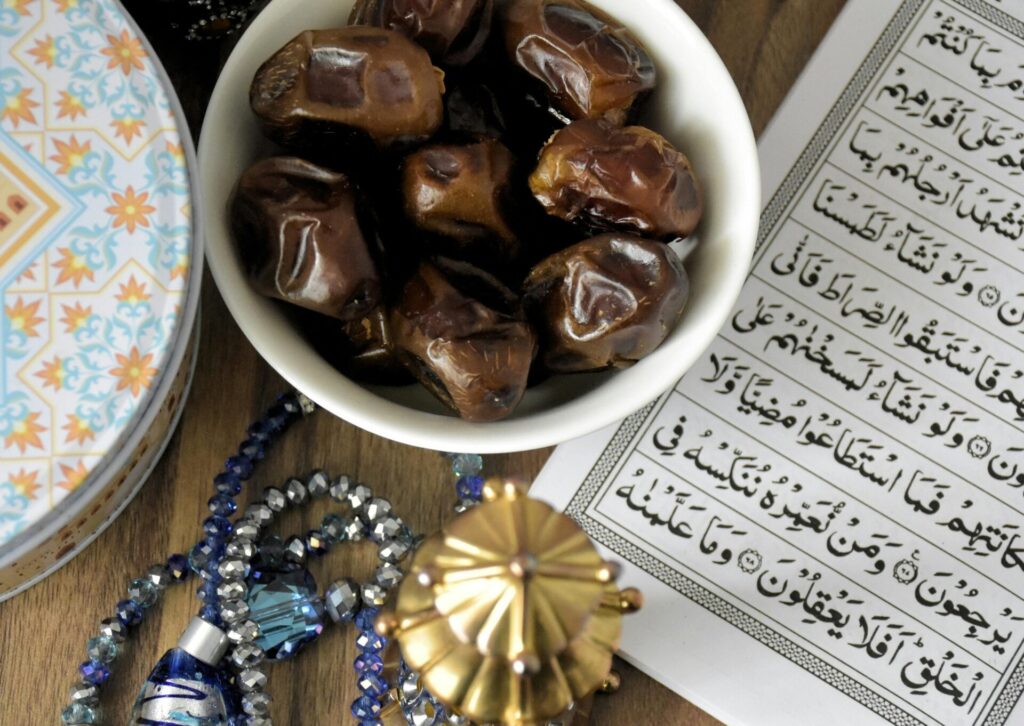 Miska z daktylami obok Koranu i modlitewnych koralików podczas ramadanu w ZEA