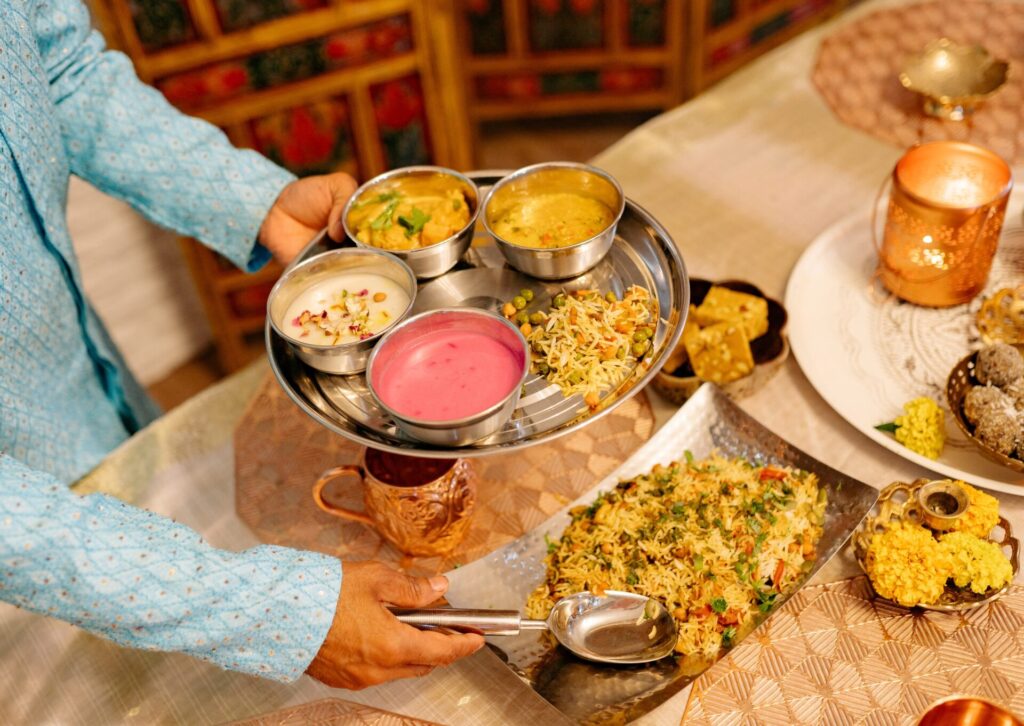 Indyjskie thali z ryżem, sosami, curry i dodatkami podane na metalowej tacy