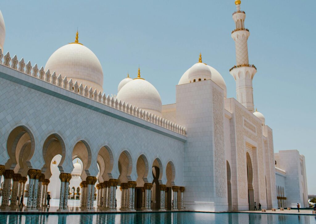 Białe kopuły i minaret meczetu w Abu Dhabi w słoneczny dzień podczas ramadanu
